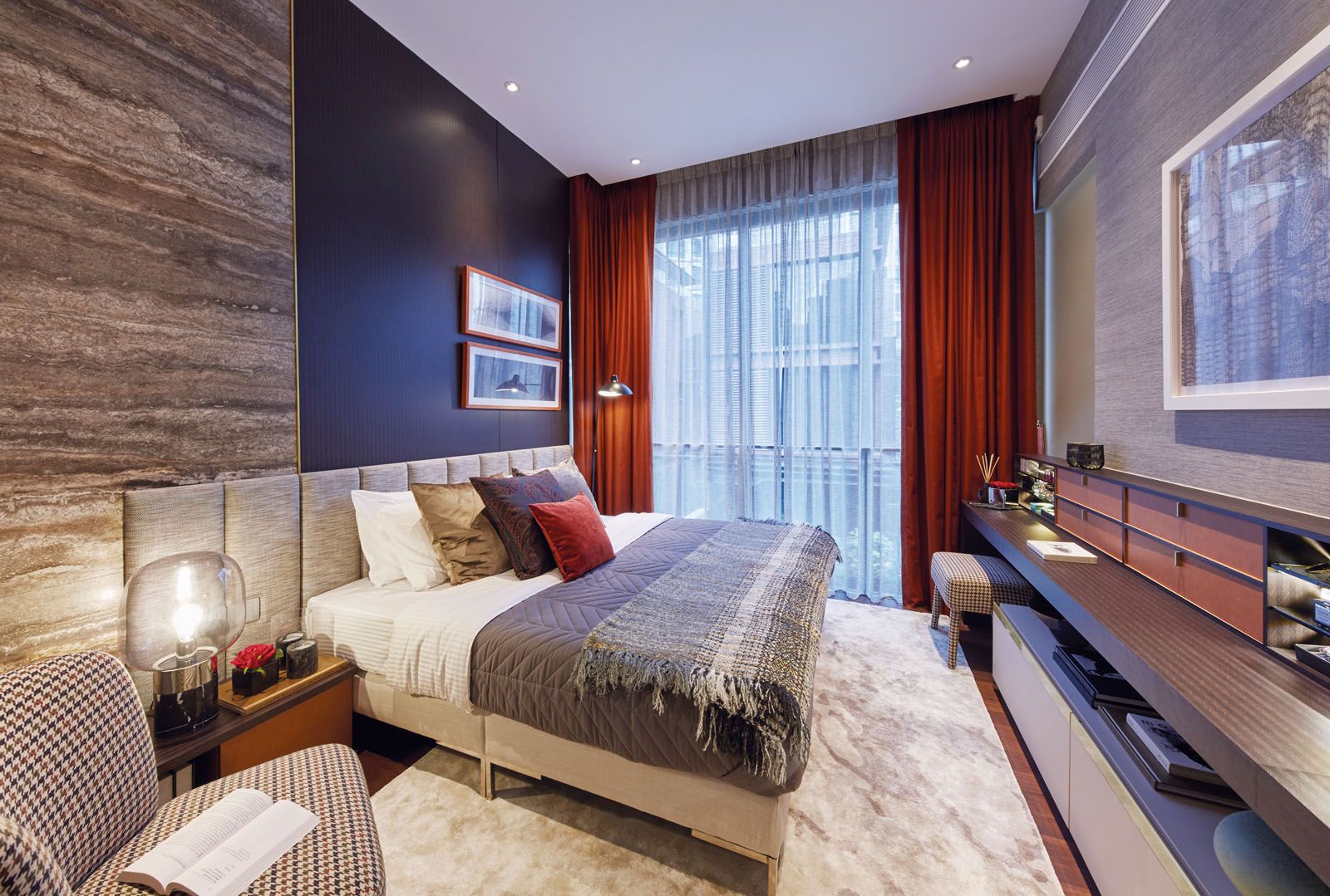 Burnt orange hues on the curtains and accent pieces add a lively touch to the master bedroom