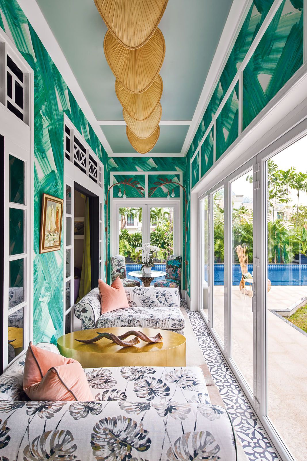 The enclosed terrace features botanical motifs and Punkah fans that reinforce its tropical context