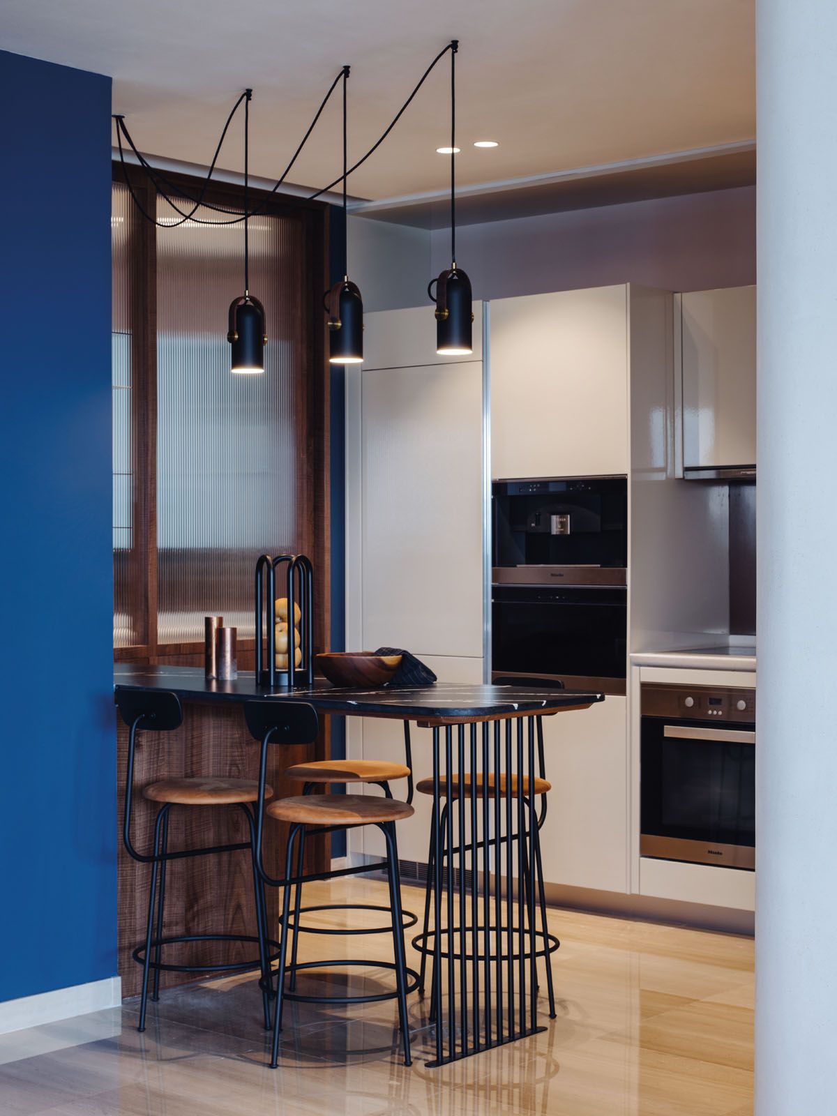 The kitchen features the Corronade pendant lights from Le Klint, Menu Afteroom bar stools and a custom-designed bar with a Dekton countertop