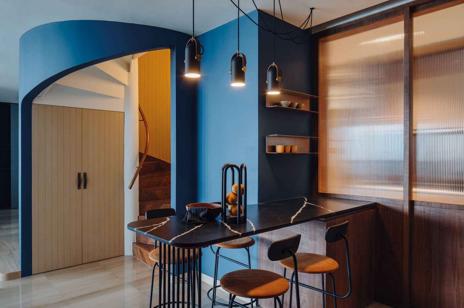 The original wall between the dry and wet kitchens has been replaced by an elegant fluted glass partition