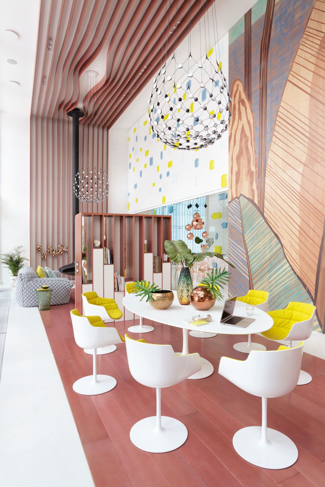 The Saarinen dining table by Eero Saarinen for Knoll is surrounded by the Flow Slim chairs by Jean Marie-Massaud for MDF Italia