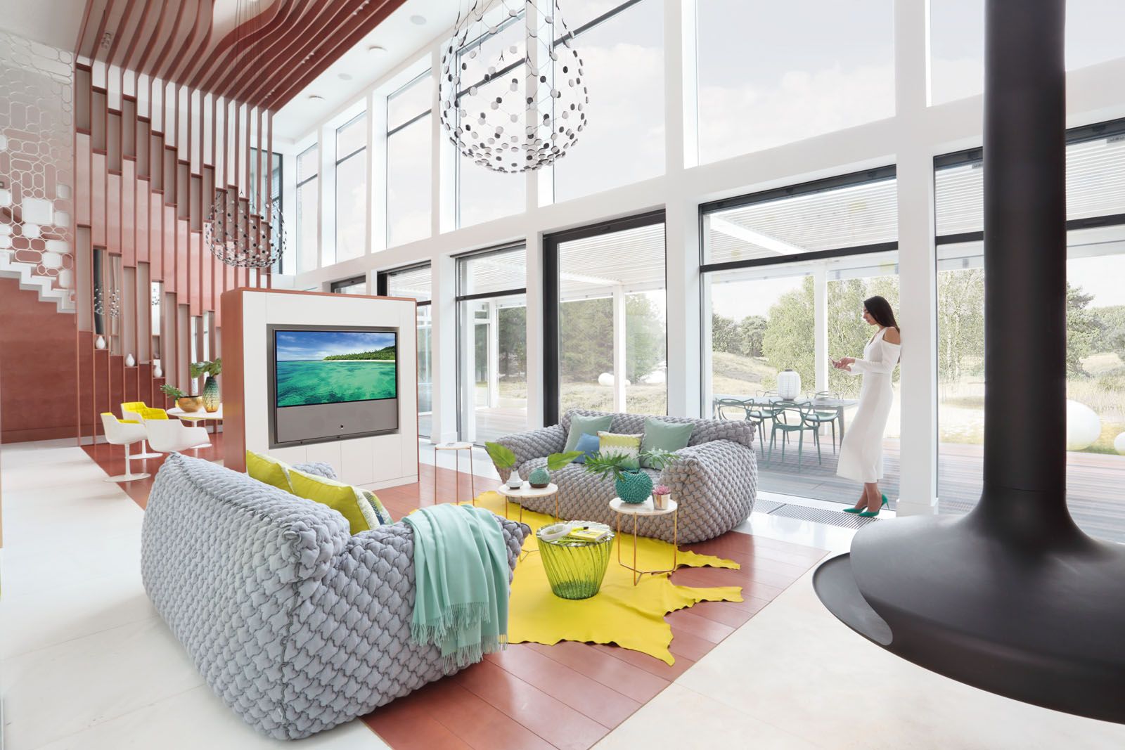 A freestanding console houses the Loewe TV while acting as a divider that separates the living area from the dining space