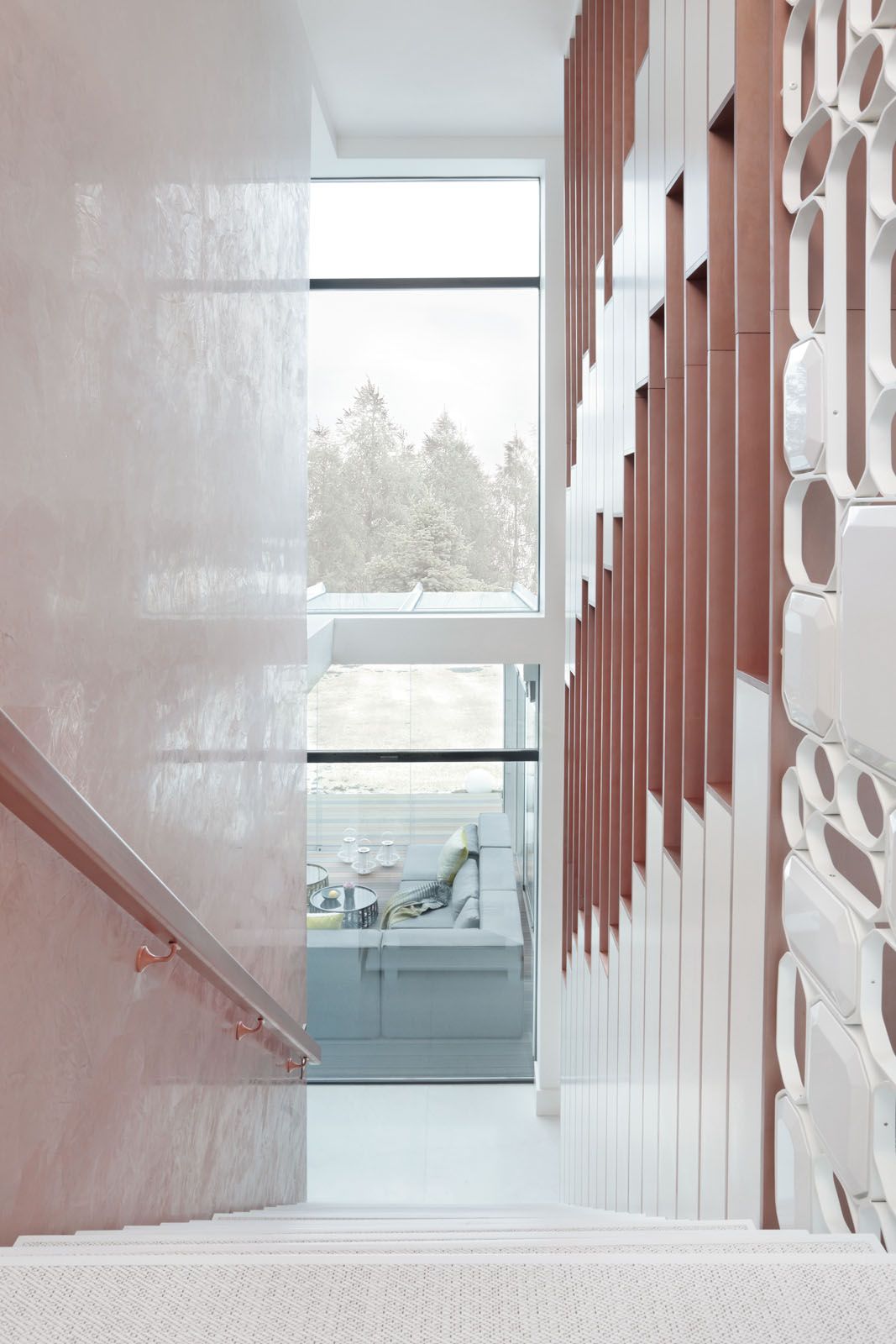 The gridwork by the staircase continues the geometric motifs from the ground floor