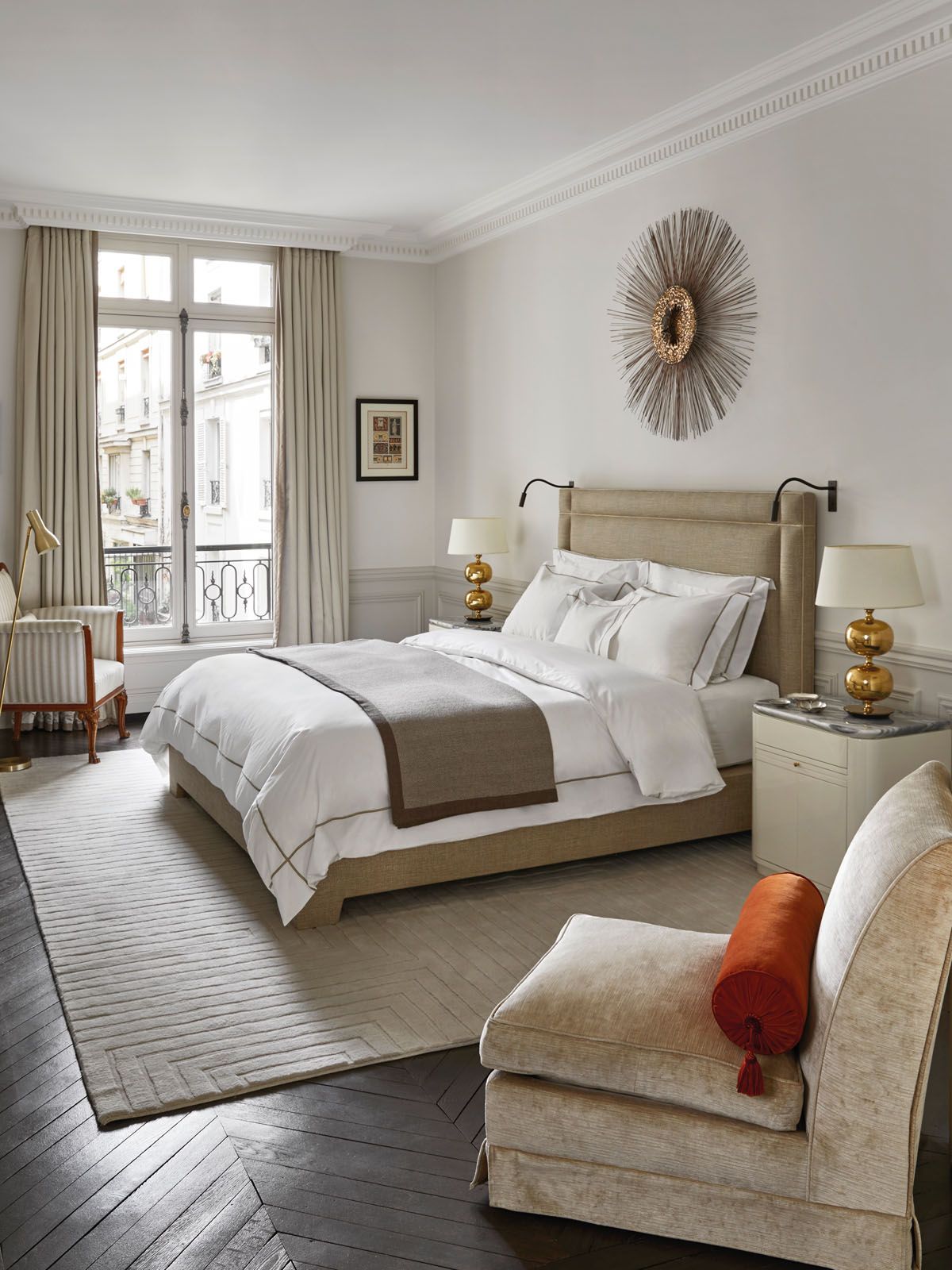 The master bedroom features a custom-made headboard, a Curtis Jere sculpture and vintage table lamps
