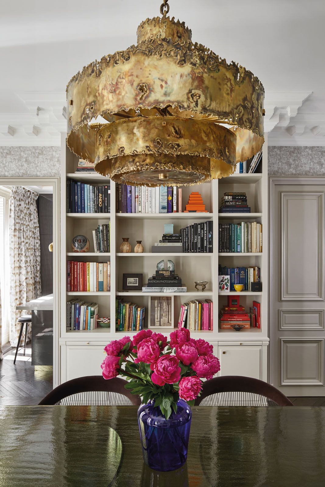 A gold pendant light by Robert Lemariey is the centrepiece of the dining room