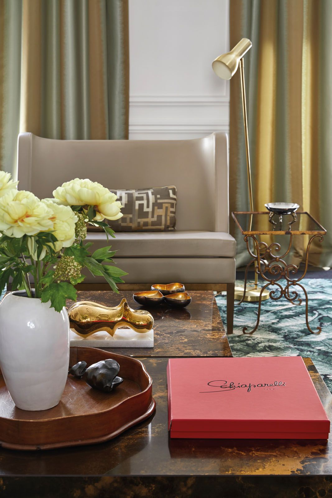 Objects on the coffee table include a Jonathan Adler Hippopotamus figurine, an antique turned wood tray and bronze sculptures by Manuela Zervudachi