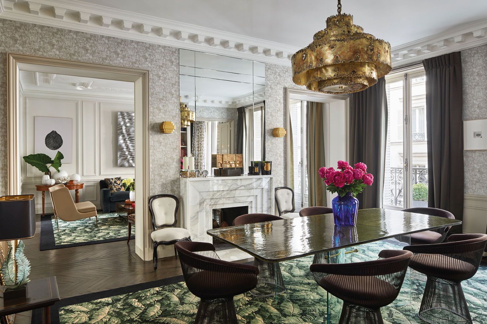 A vintage glass dining table is paired with the iconic Platner armchairs designed by Warren Platner for Knoll