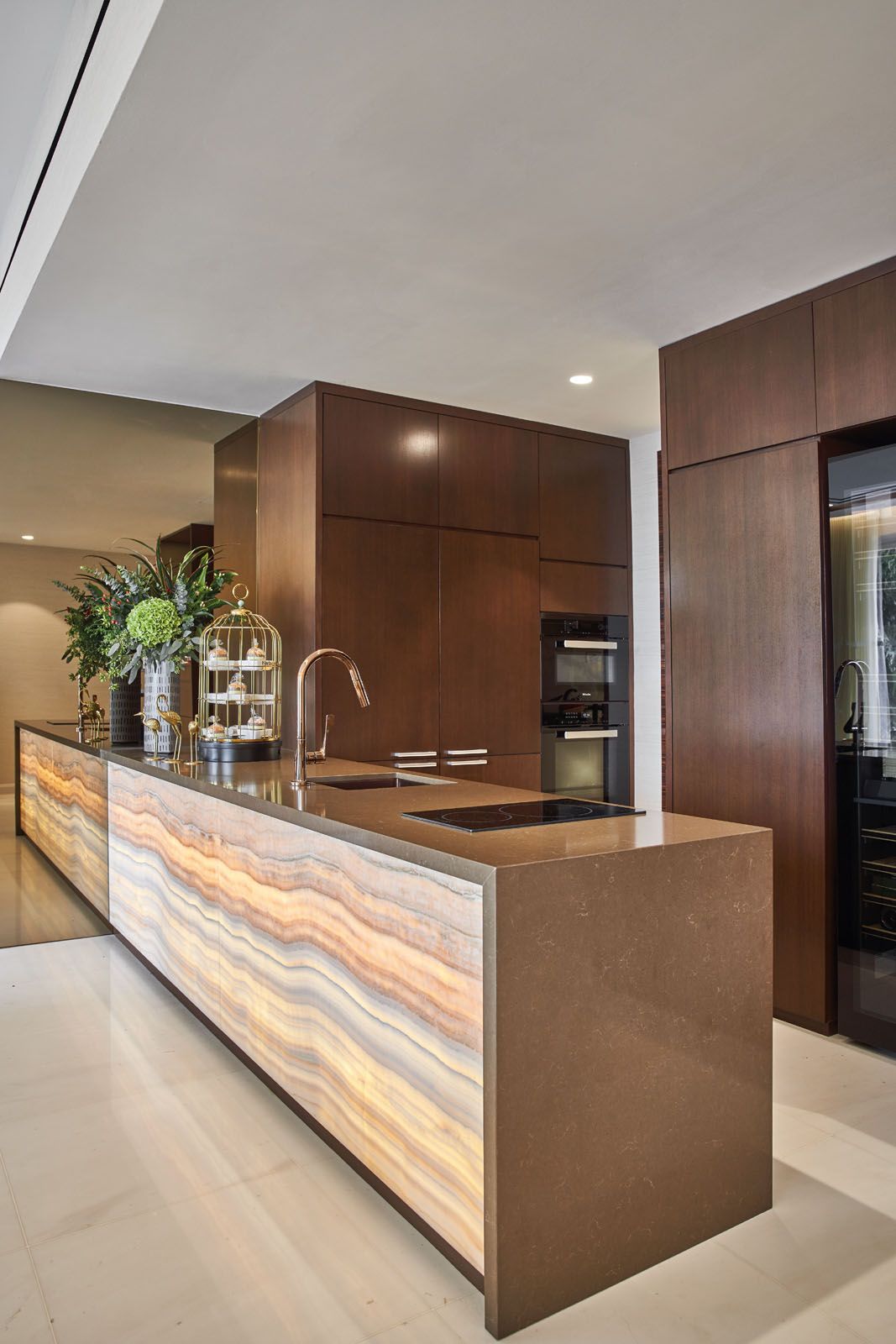 The dry kitchen features a back-lit honey onyx counter and Miele appliances