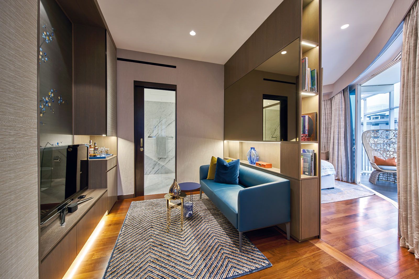 A wooden divider separates the husband’s TV lounge from the bed area