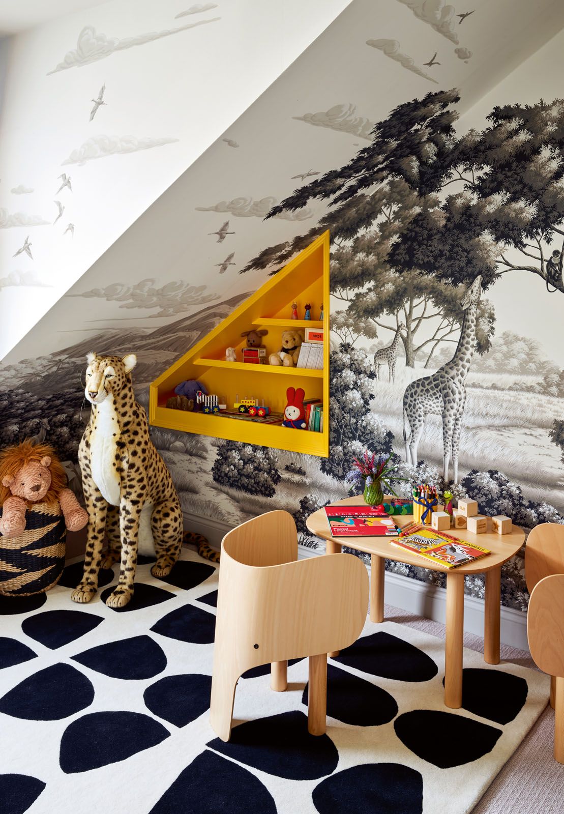 The triangular yellow shelves store the children’s toys while adding a pop of colour to the playroom