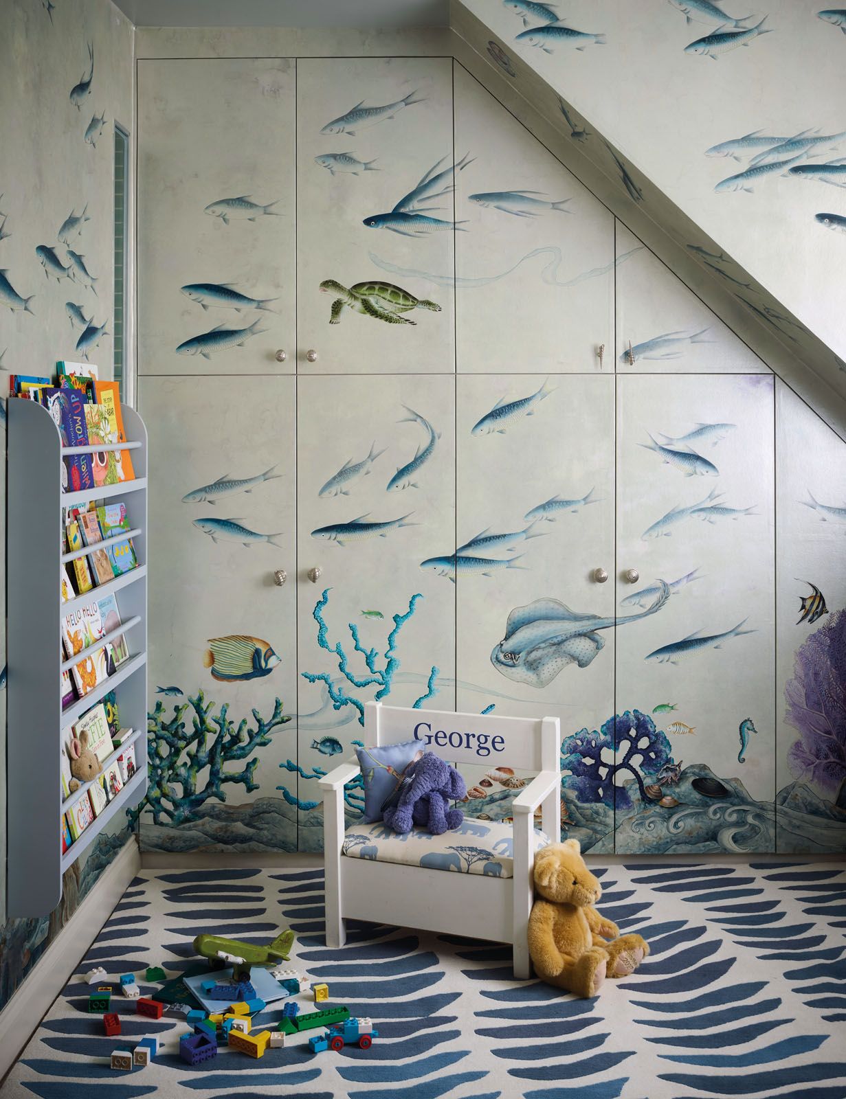 A custom wallpaper swimming with marine life brings a lively dimension to George’s blue bedroom