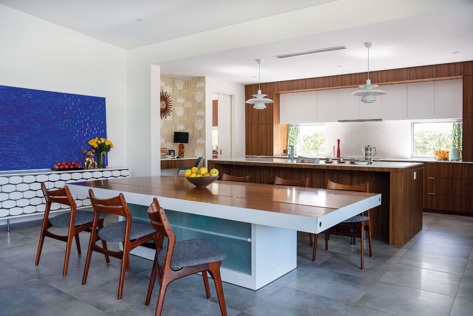 The kitchen features cabinetry and pieces in hazelnut veneer and a pair of Louis Poulsen PH 5 pendant lights by Poul Henningsen