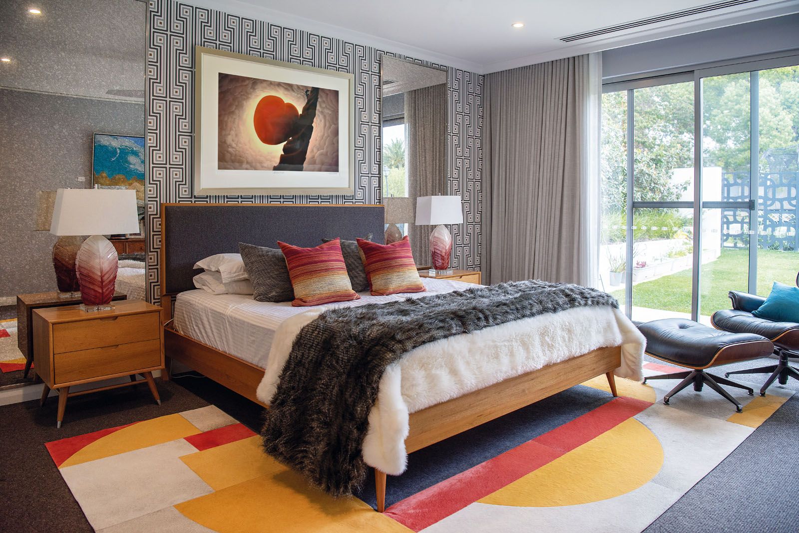 The vibrant colours on the rug and accent pieces bring a cheerful energy to the master bedroom