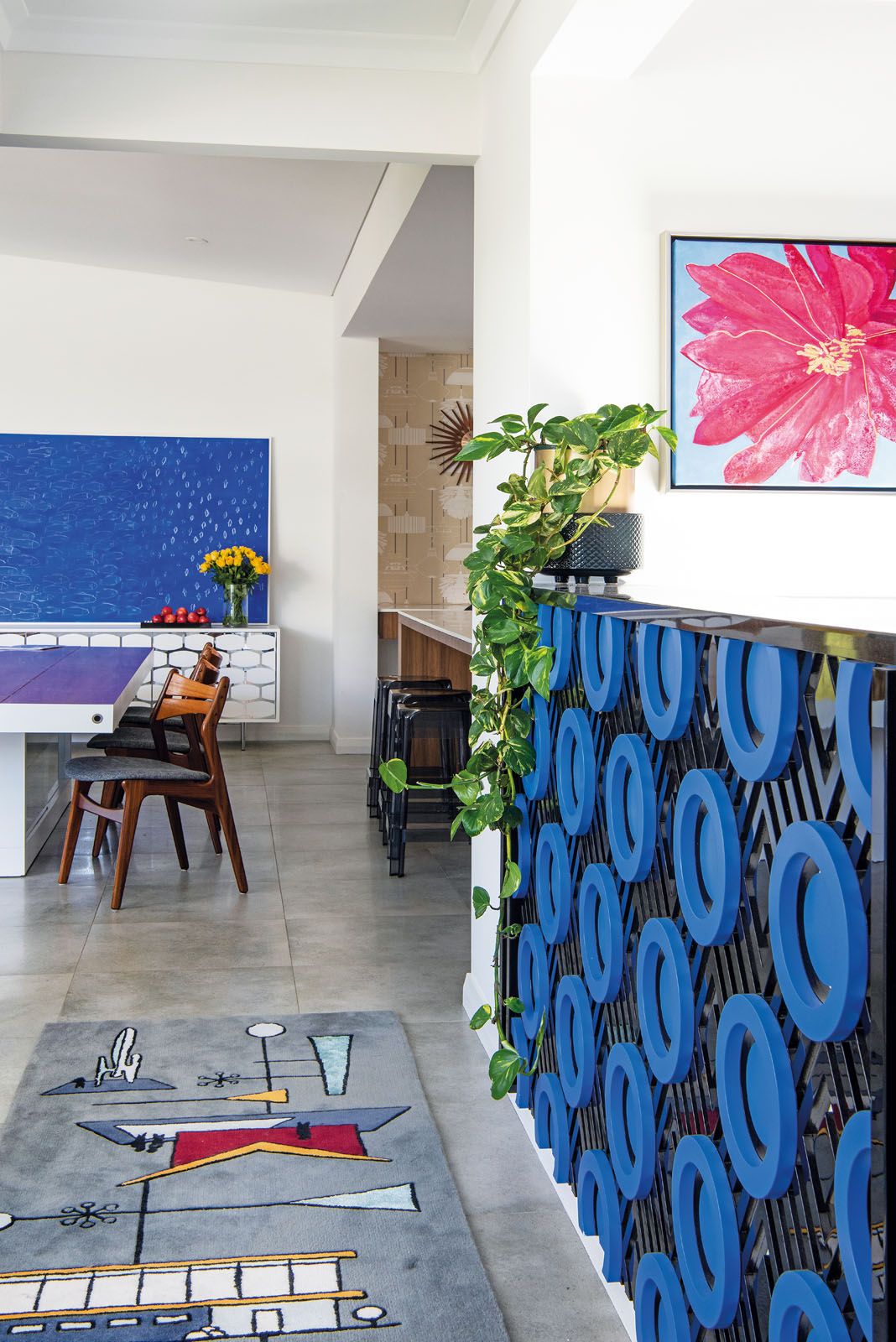 Bespoke pieces in this area include the bar counter and a custom-made rug featuring geometric motifs inspired by mid-century modern design