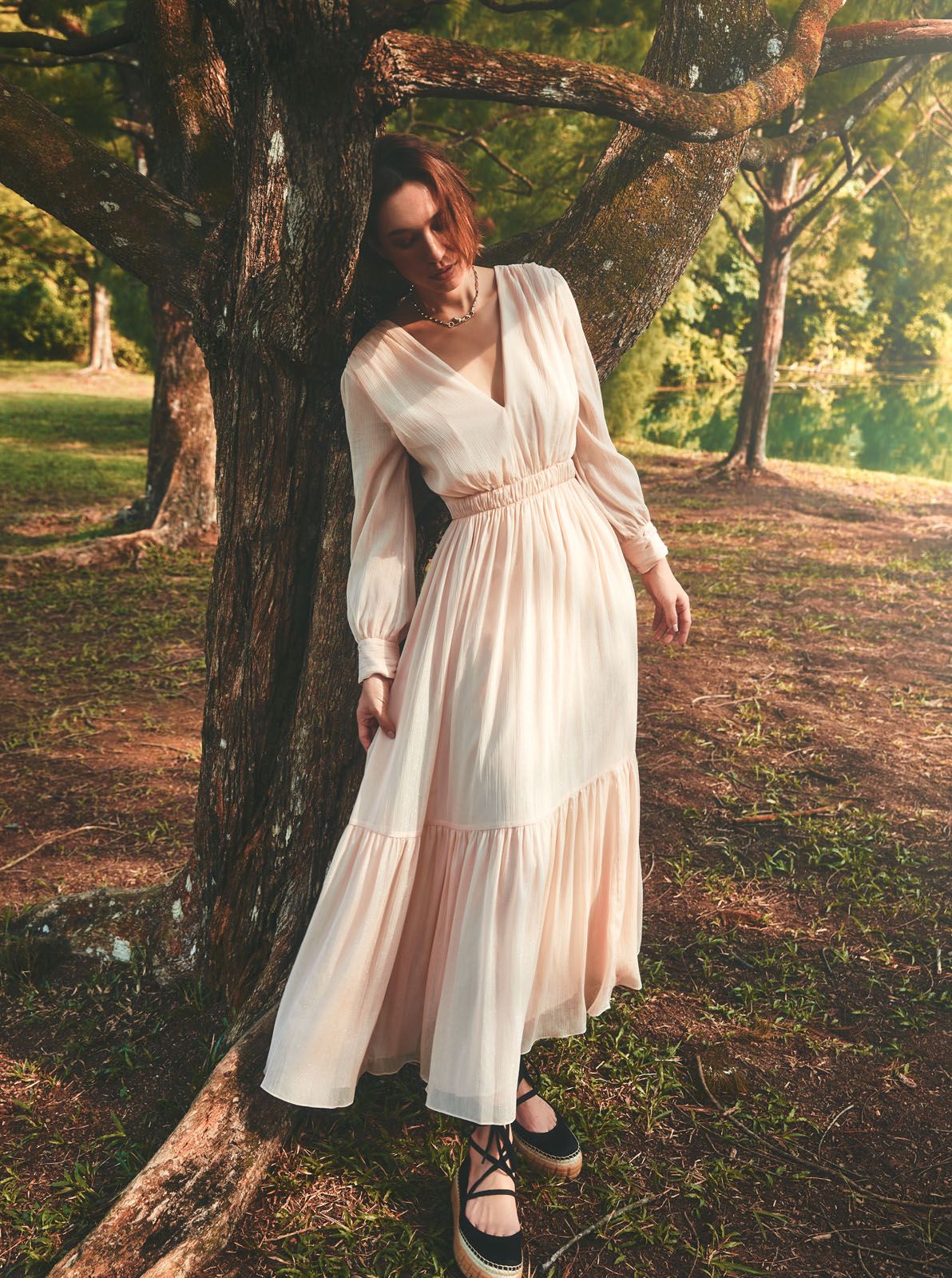 Polyester pleated dress by Sandro; Panthère de Cartier necklace in yellow gold with lacquer, diamonds and tsavorite garnet by Cartier; satin ballerina shoes by Prada