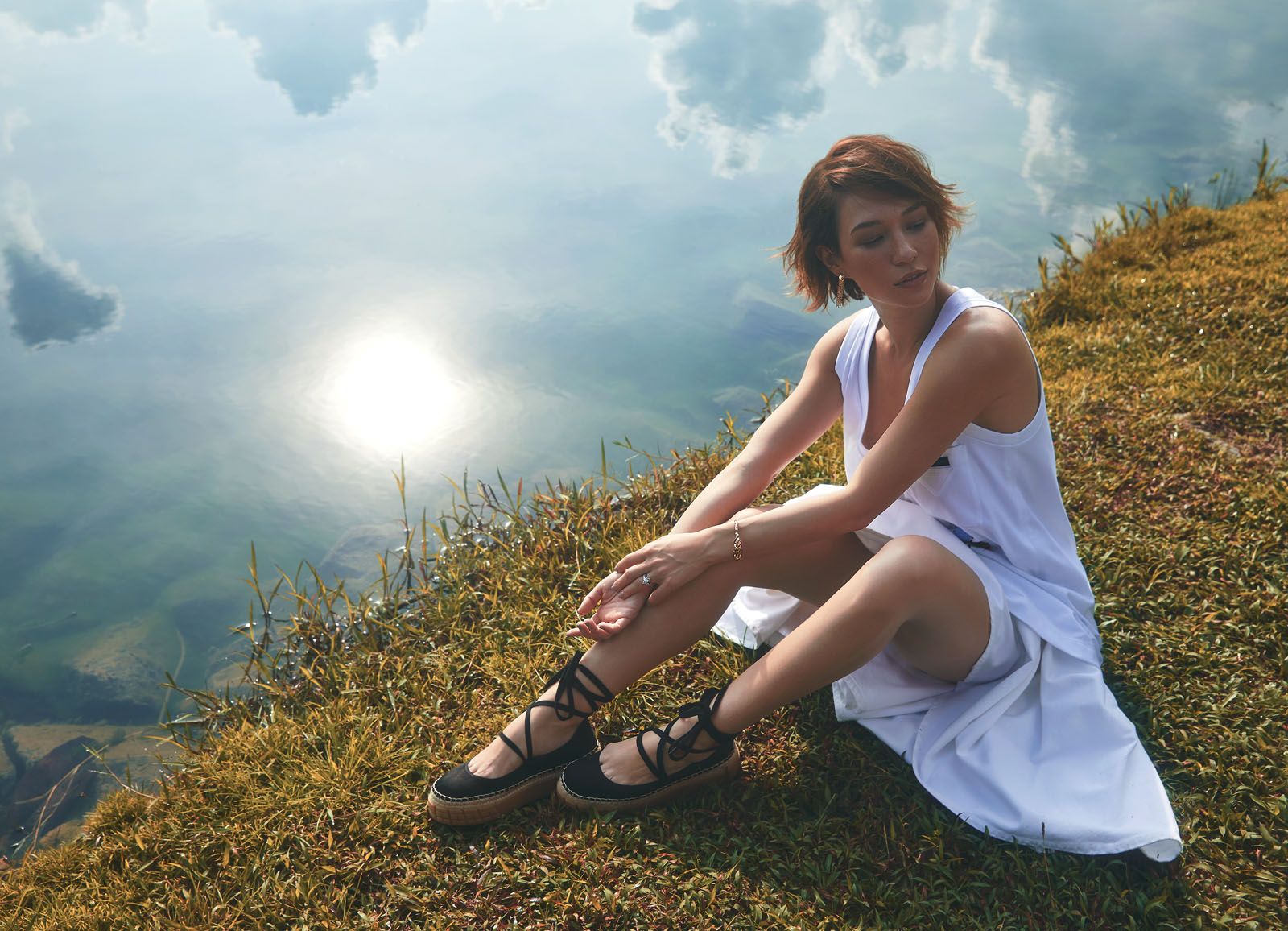 Cotton top with embroidery, cotton pleated skirt and satin ballerina shoes, all by Prada; Panthère de Cartier earrings in yellow gold with diamonds, tsavorite garnets and onyx, and Panthère de Cartier bracelet in yellow gold with tsavorite garnets and onyx, both by Cartier