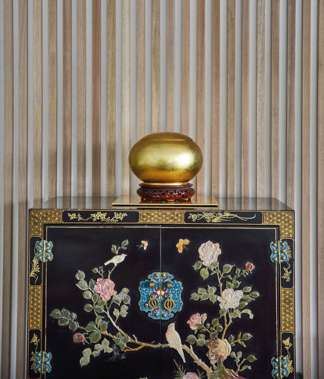 Wooden slats create a modern backdrop to showcase the antiques in the home