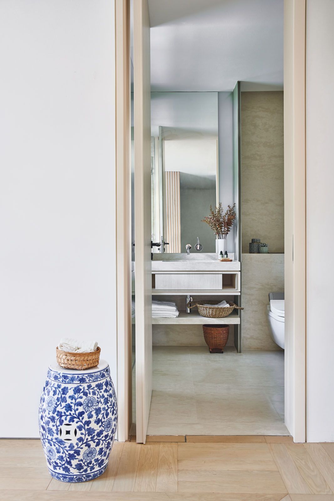 The material palette in the bedroom is a calming mix of light wood and natural stone