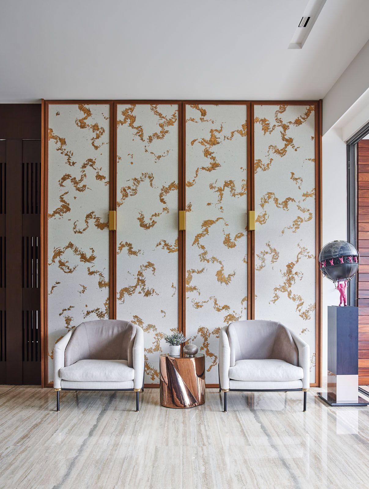The wallpaper panels by the entrance feature glass beads and gold leaf detailing