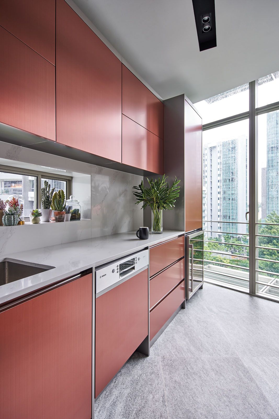 Bosch appliances are seamlessly integrated into the rose-gold stainless steel cabinets in the kitchen