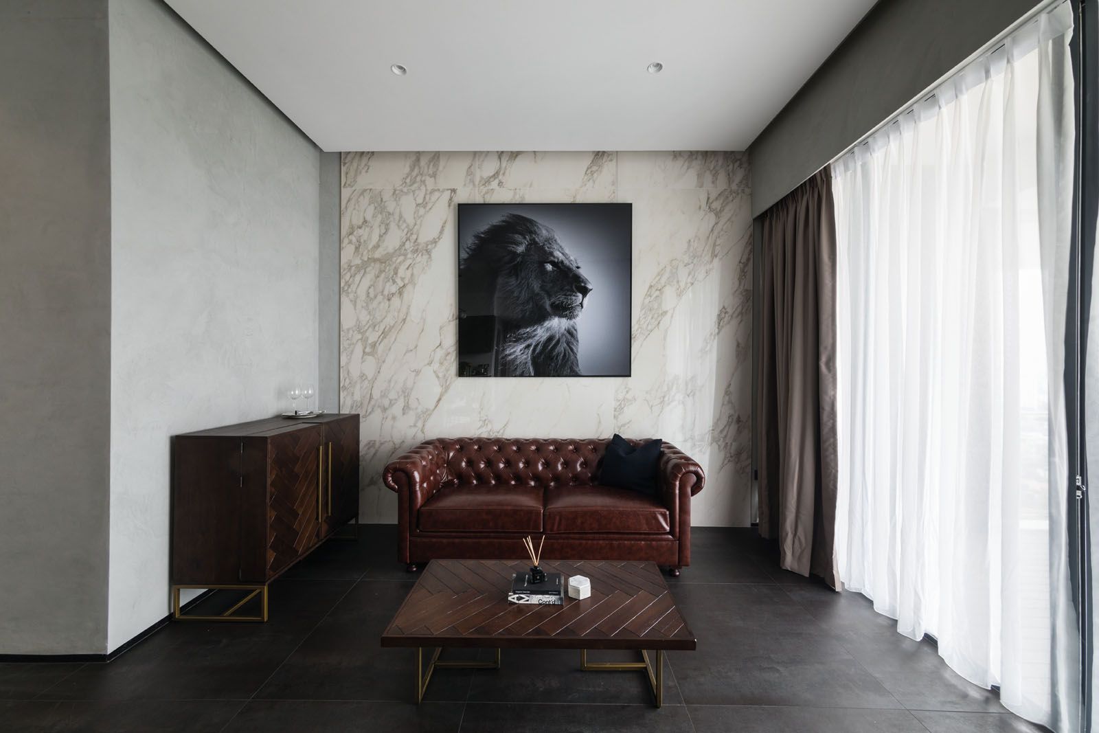 The stucco used for the walls in the living room serves as a neutral background that provides a stylish contrast when paired with leather, timber and marble