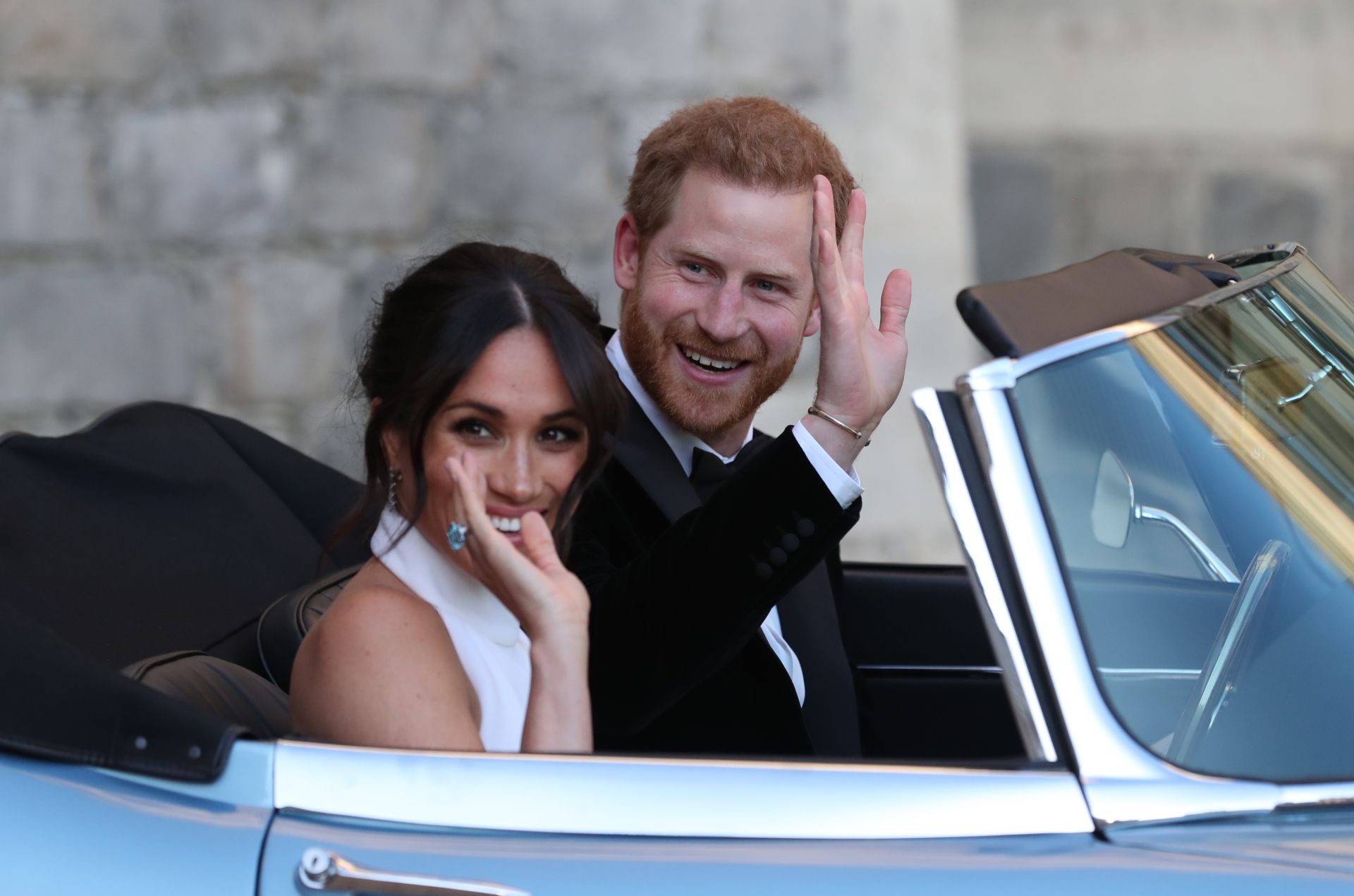 Britain's Prince Harry, Duke of Sussex, (R) and Meghan Markle, Duchess of Sussex, (L) leave Windsor Castle in Windsor on May 19, 2018 in an E-Type Jaguar after their wedding to attend an evening reception at Frogmore House. / AFP PHOTO / POOL / Steve Parsons