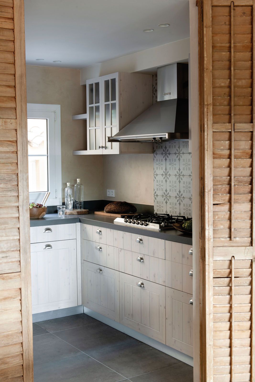 Wooden bifold shutters separate the kitchen from the dining and living areas