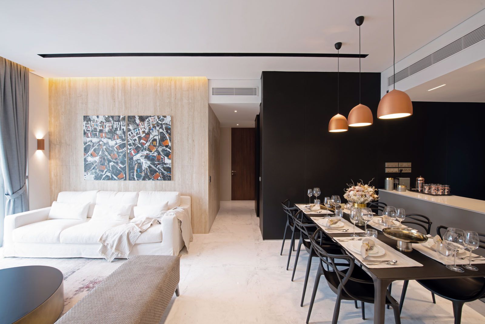 The earthy tones of the travertine wall are juxtaposed against the sleek black laminate wall that wraps around the kitchen, dining area and hallway