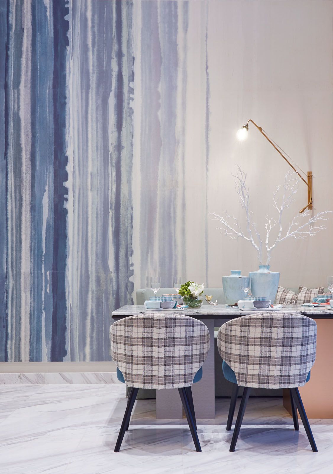 The tartan pattern on the dining chairs is a playful touch at the dining area; the upholstered headboard and the various accent cushions add to the cosy environment in the master bedroom