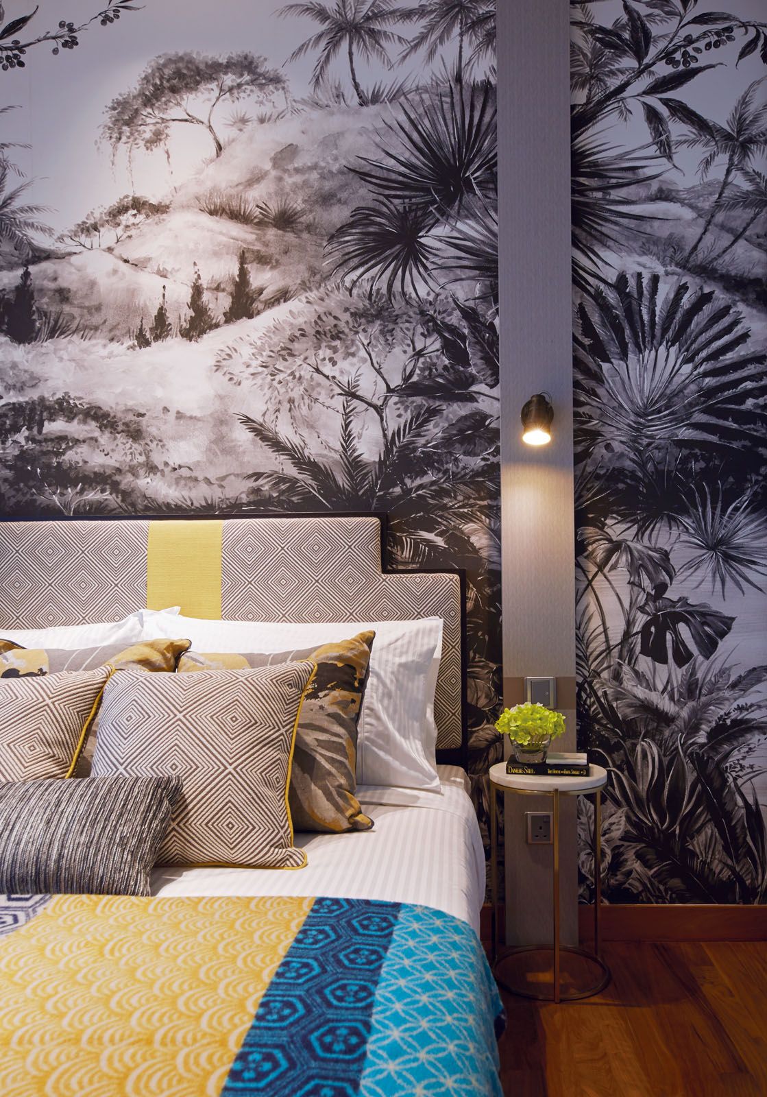 The botanical influence continues in a guest bedroom with a wallpaper covered with leaf motifs