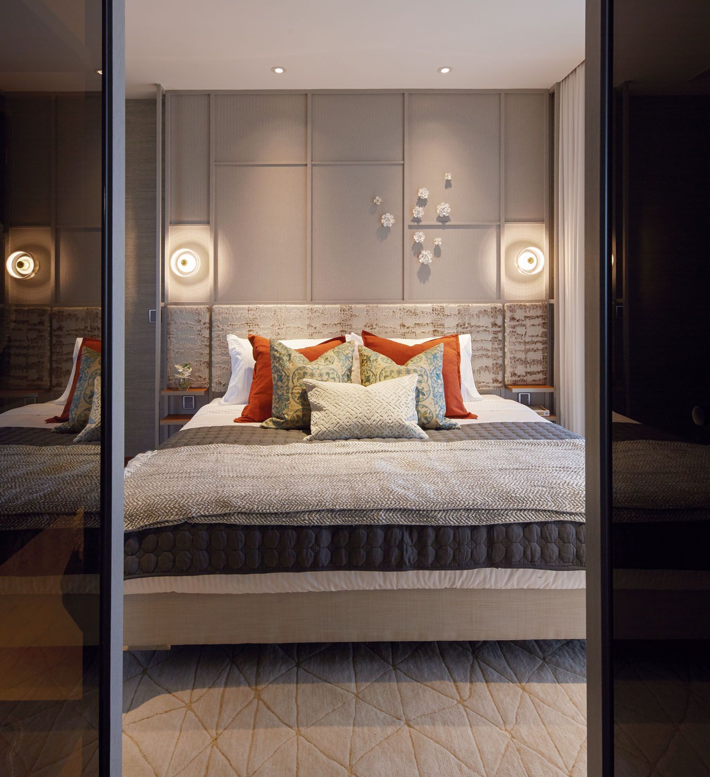Tawny accent cushions add pops of colour to the understated master bedroom;