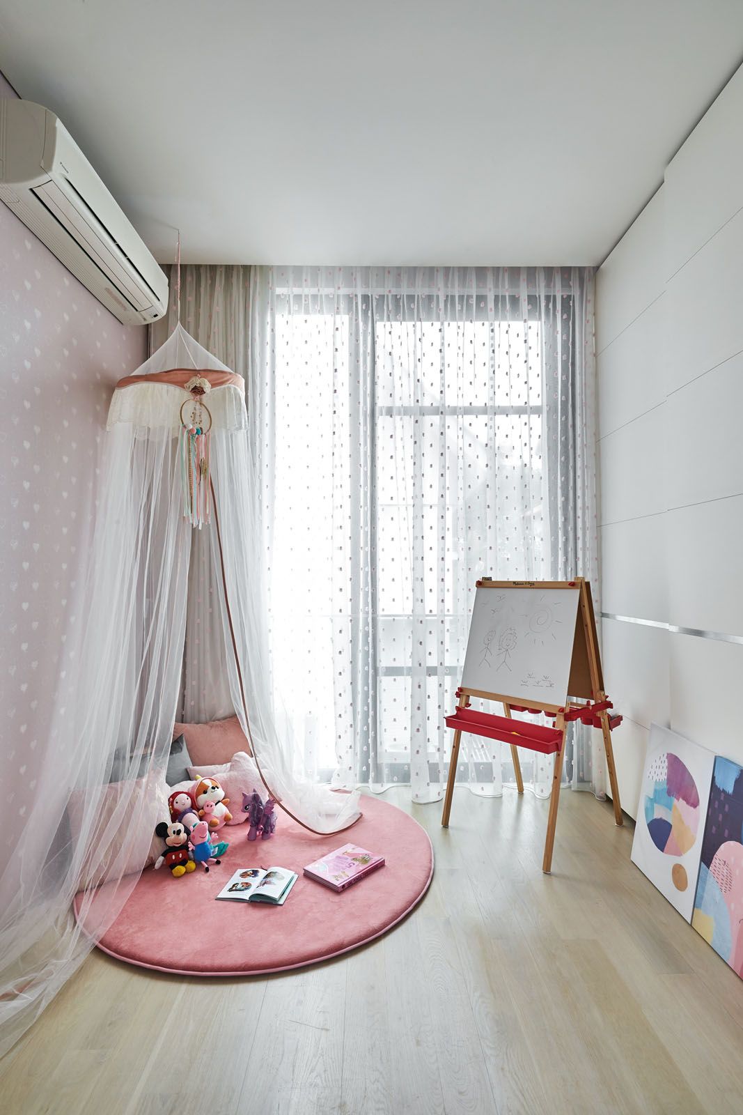 Sheer curtains create an air of whimsy in the daughter’s play area