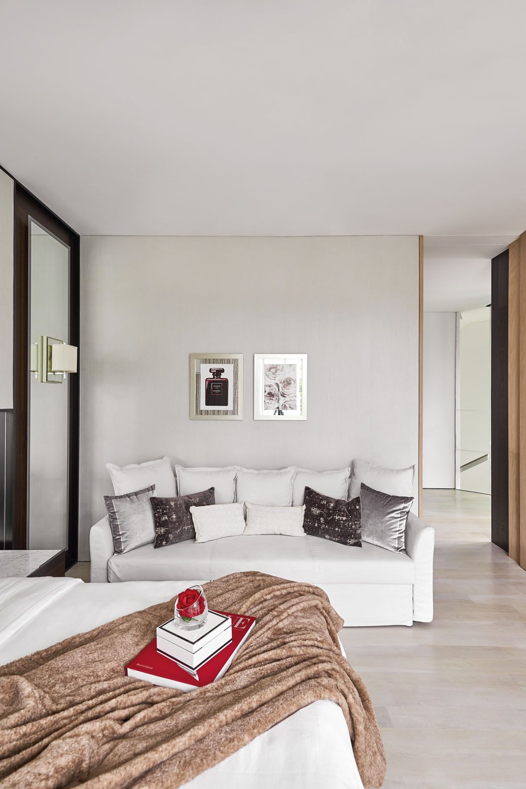Designed by KGID, the master bedroom features a custom-made headboard, mirrored panels, velvet upholstery and Barbara Barry wall lights