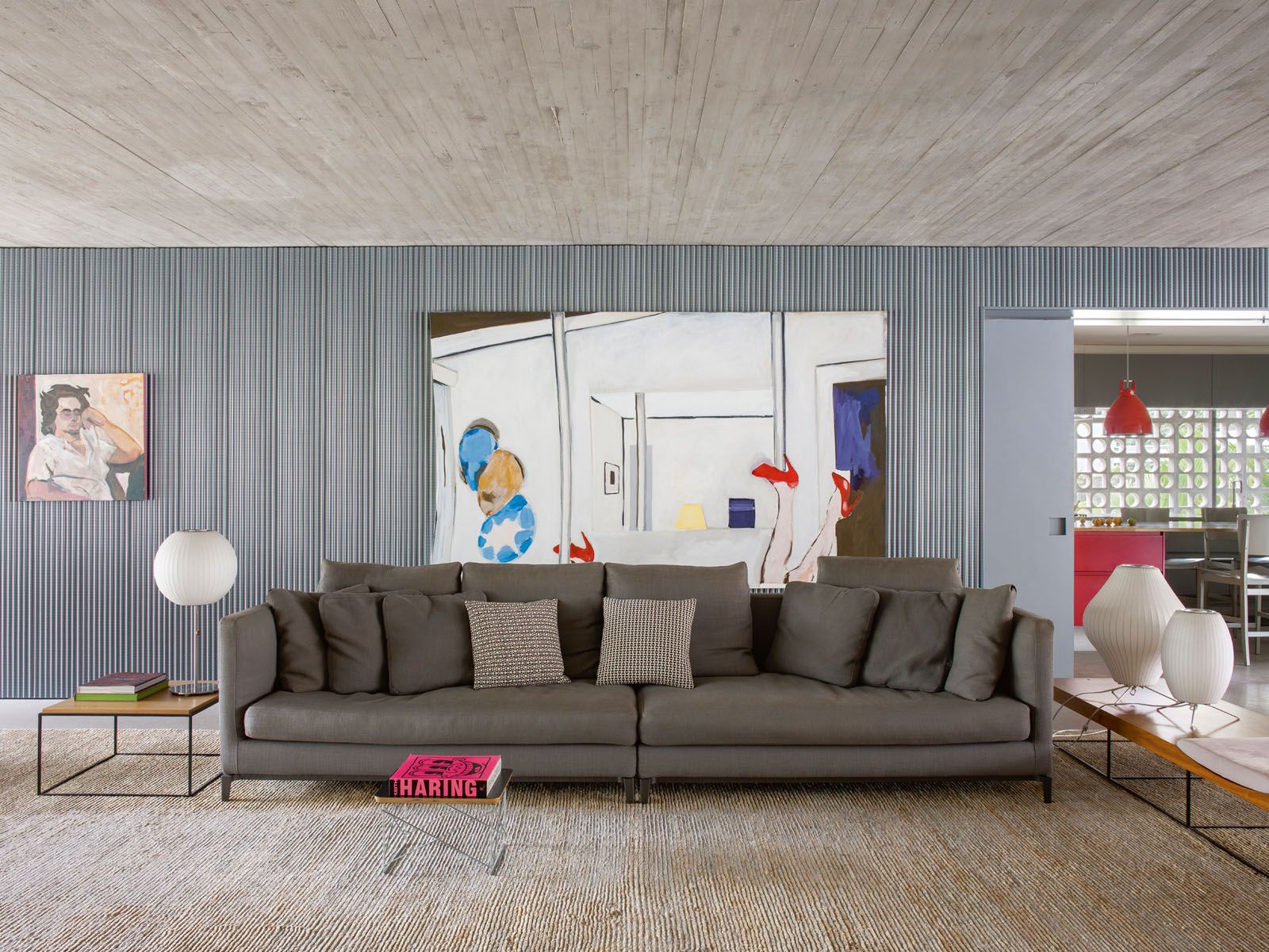 A rug by Phenicia Concept adds a snug touch underfoot in the living room, which also features paintings by Brazilian artists Duane Benatti and Tomie Ohtake