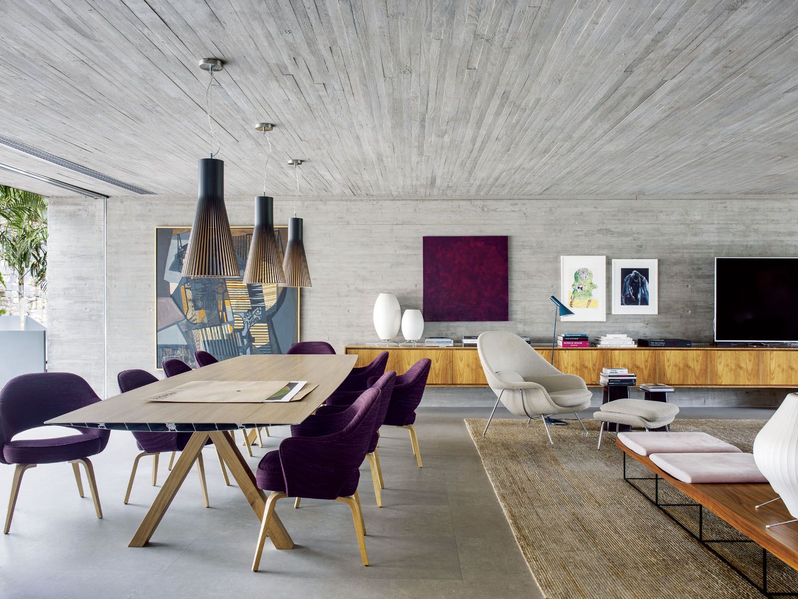 The dining area features the Knoll Saarinen Executive armchairs by Eero Saarinen, BD Barcelona Table B by Konstantin Grcic and Secto Design Magnum 4202 pendant lights;