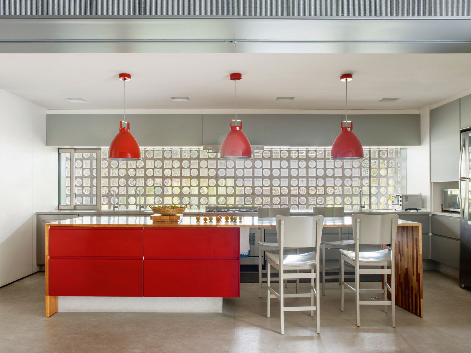 The red cabinetry and pendant lights create visual interest in the kitchen