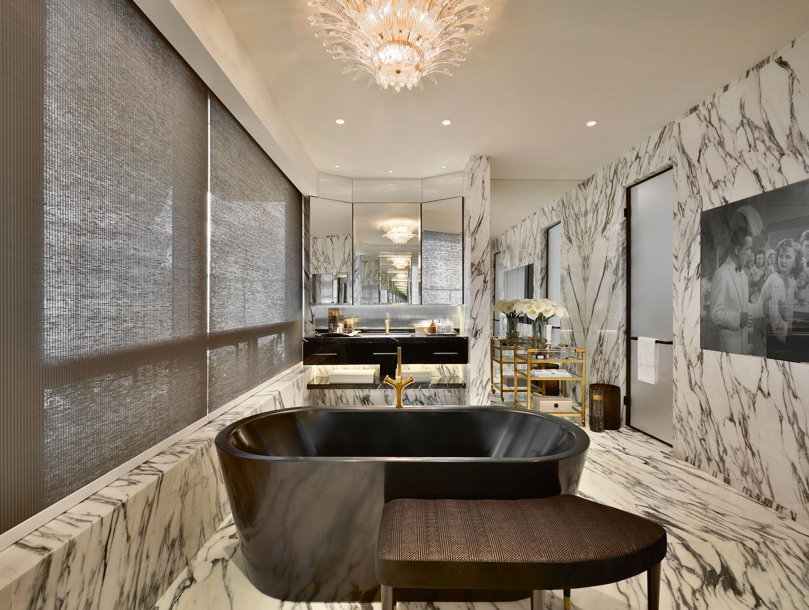 A bathroom designed by The I.D. Dept features a freestanding bathtub with an integrated audio system