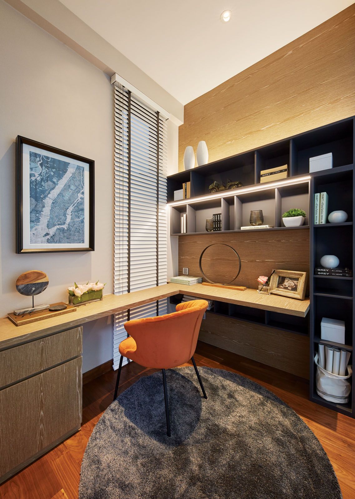 The orange armchair adds a pop of colour to the study