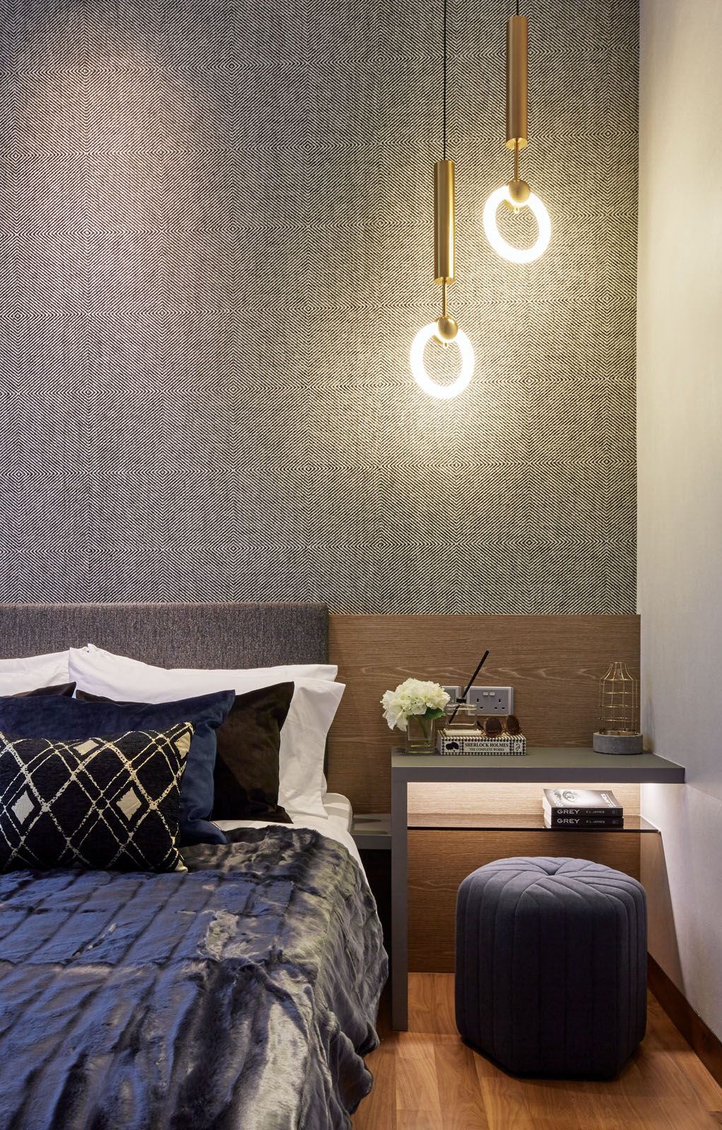 A pouf and a built-in side table create a cosy reading nook in this bedroom