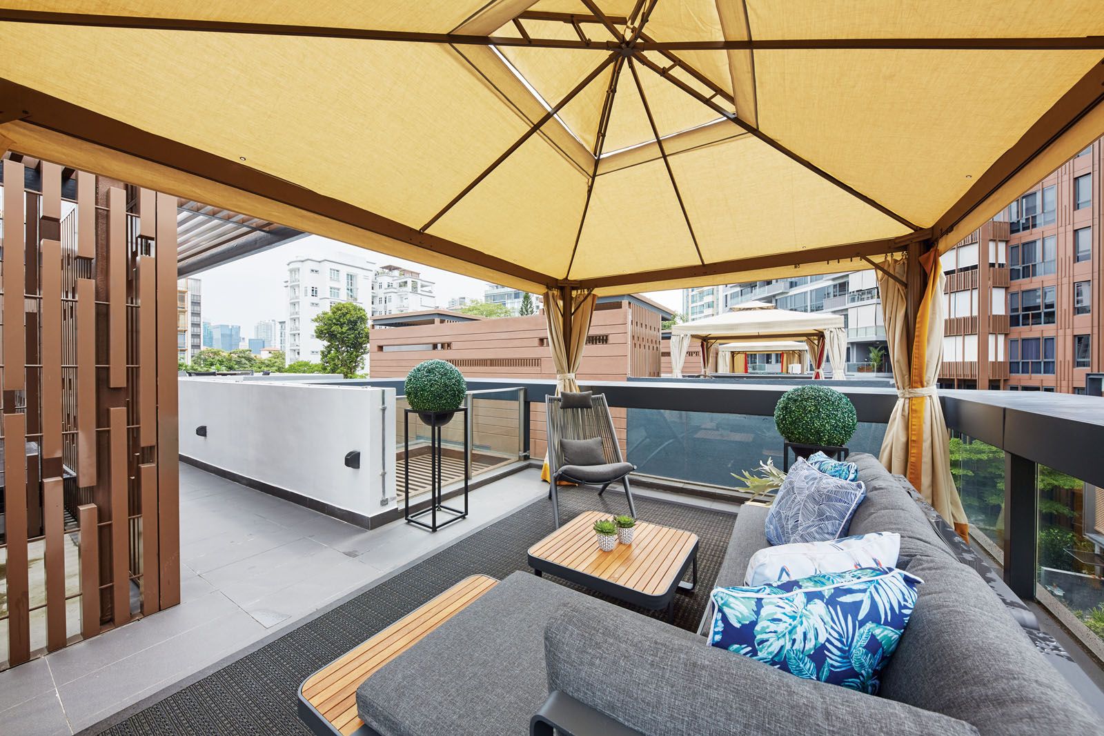 On the outdoor sofa, a melange of blue cushions evokes a resort-like feel