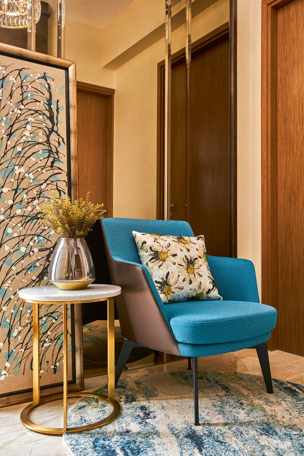 The nook with a blue armchair serves as a reading corner in the family room
