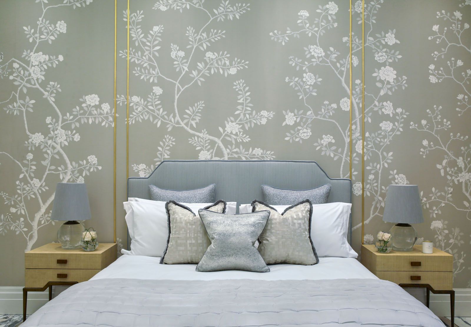 A bedroom designed by Katharine Pooley features floral wall panels lined with gold trimmings