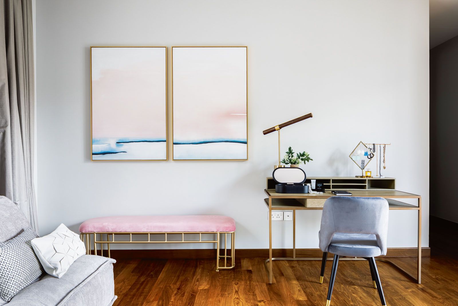 The grey wall serves as a graceful canvas for the artwork and colour furnishings in this bedroom by Designworx Interior Consultant