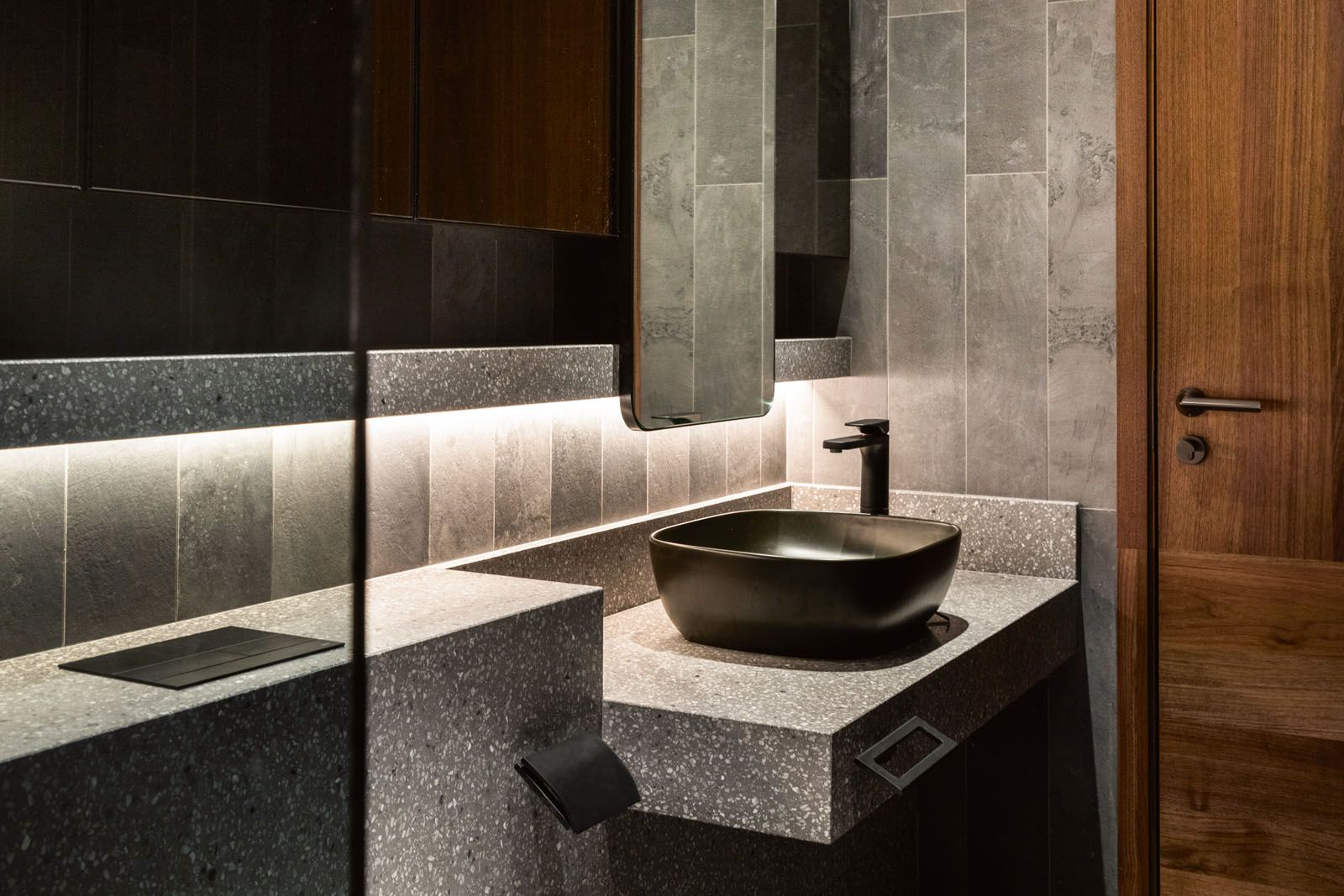 The son’s bathroom incorporates terrazzo counters and black taps