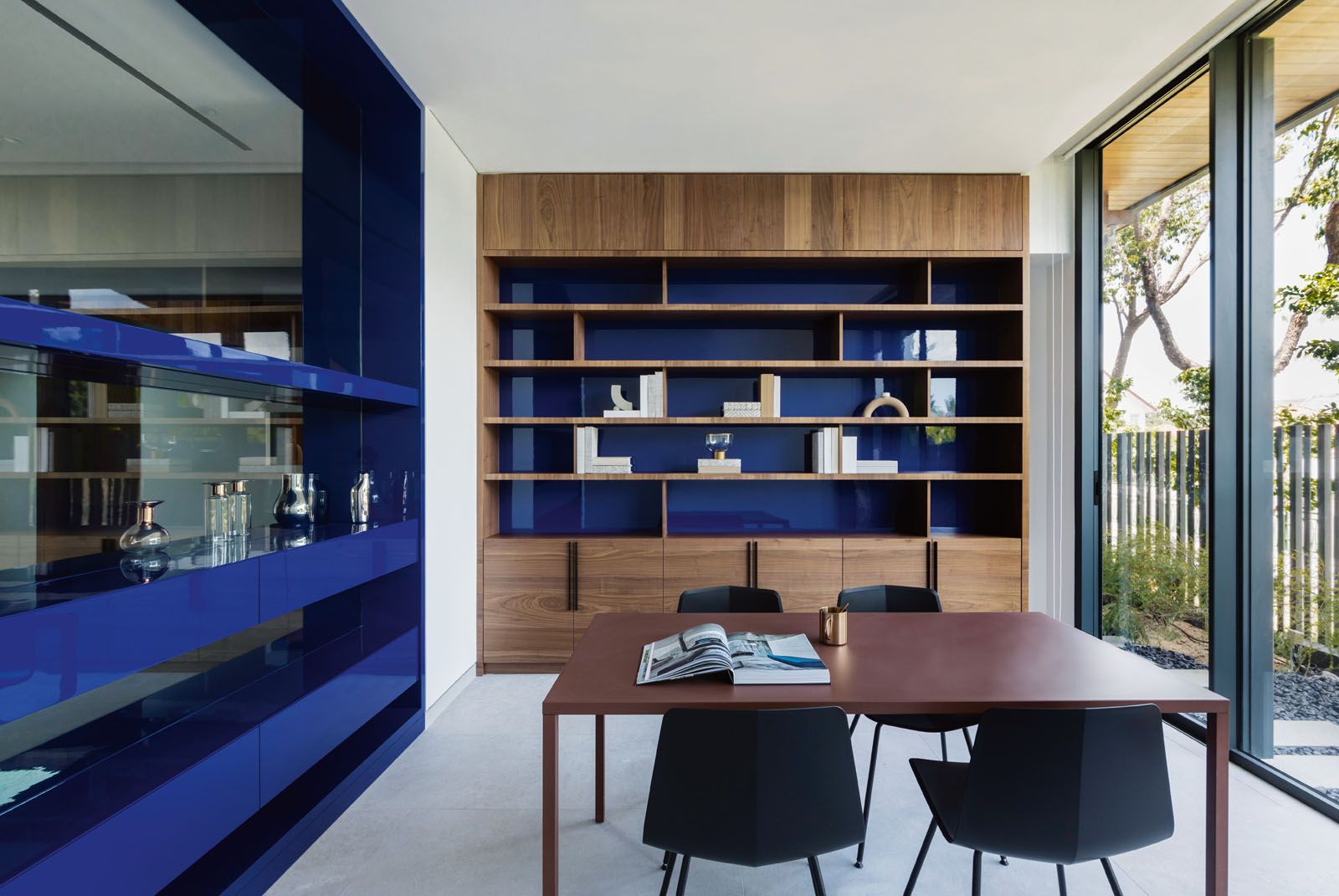 Reflective panels and blue cabinetry add to the serene mood in the study