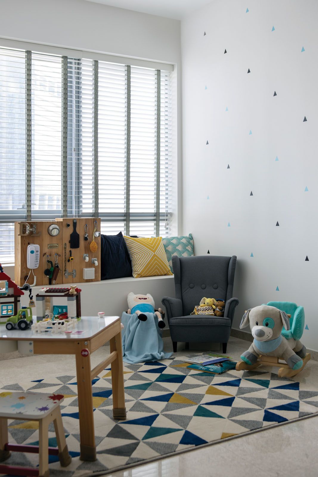 The child’s bedroom is a playful space decorated with a geometric rug and colourful accent cushions