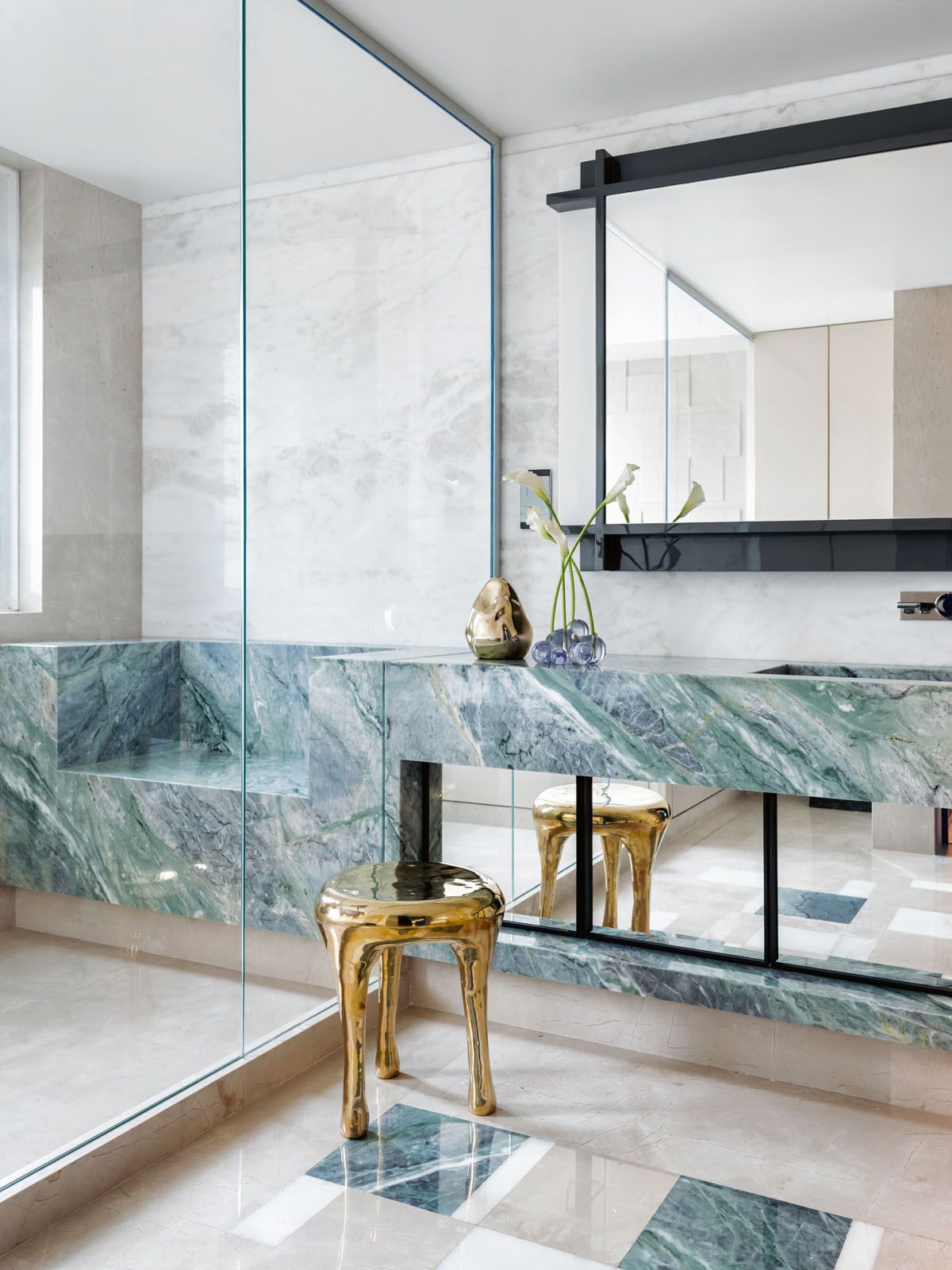 Green marble is applied to vanity and shower area of this bathroom