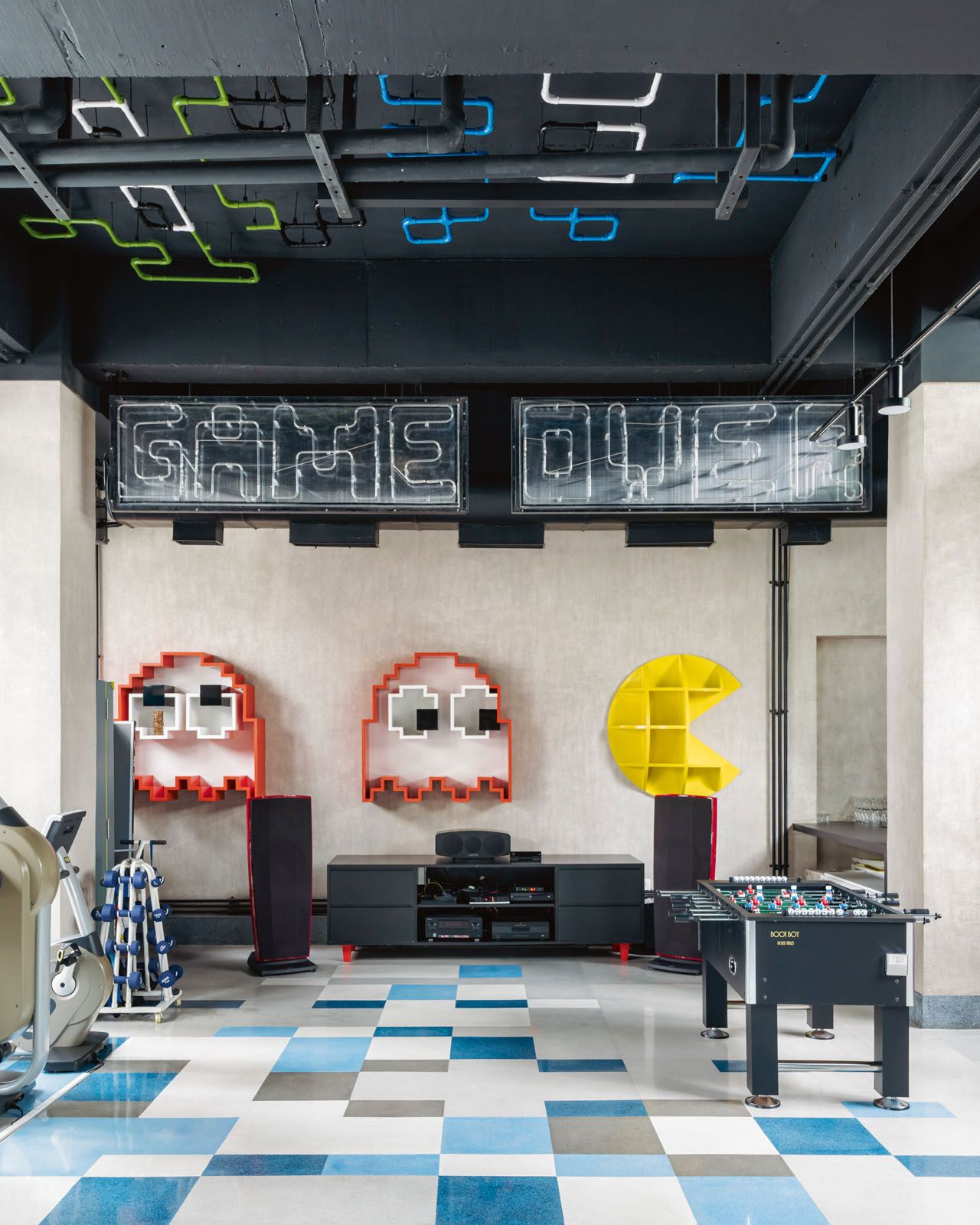 The garage features a multitude of playful elements that include Pac-Man shelves, the Game Over neon signage, a Super Mario figurine and the Scarlet Splendour Animagic Ciuco cabinet