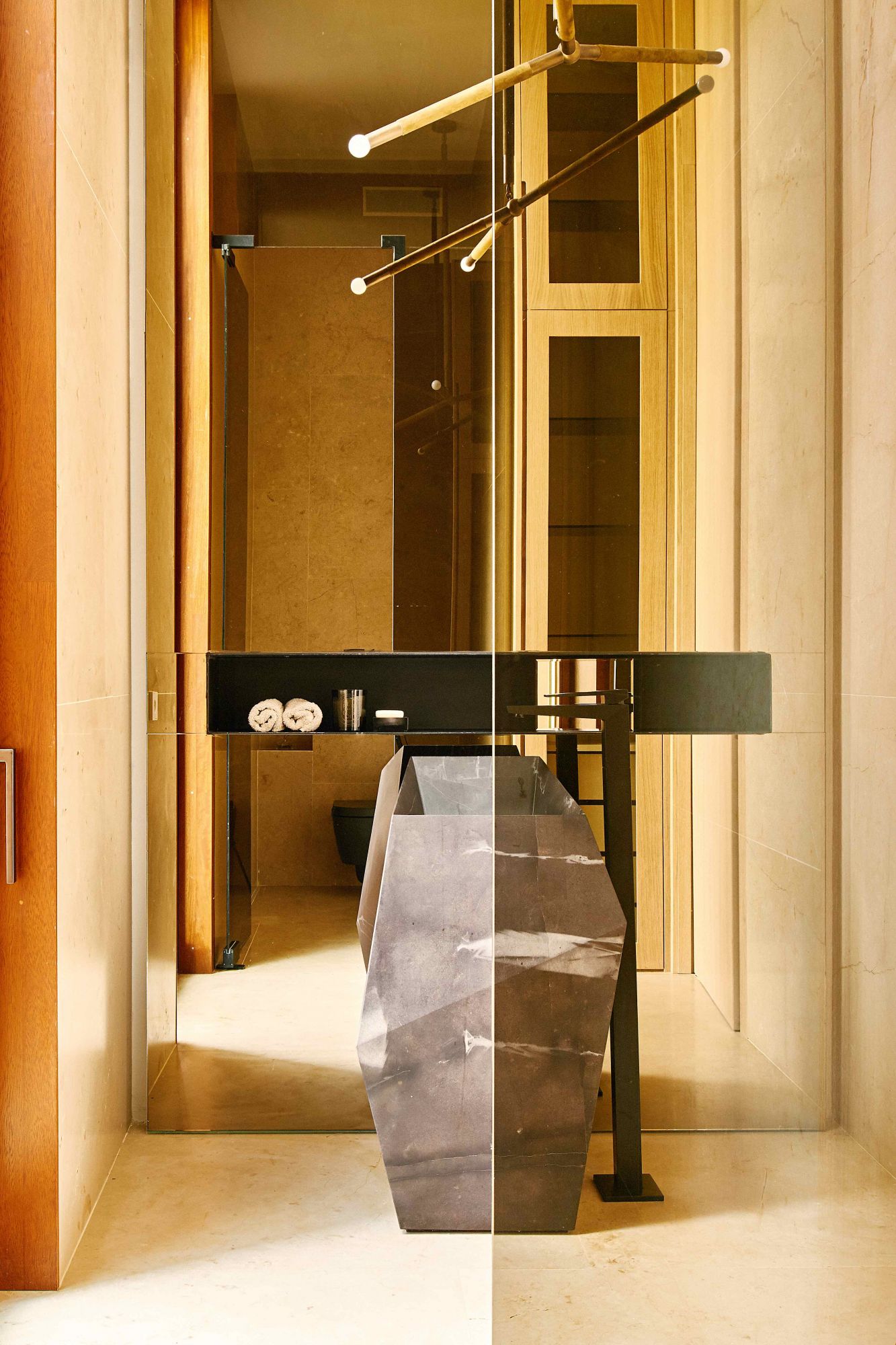 Casa diseñada por Ramon Esteve en Madrid Baño decortesÃa con lavabode la serie Facesde Ramón Estevepara LâAntic Colonial,de PorcelanosaGrupo, tallado de unbloque de piedrade Calatorao, ylámpara Arrowde Apparatus