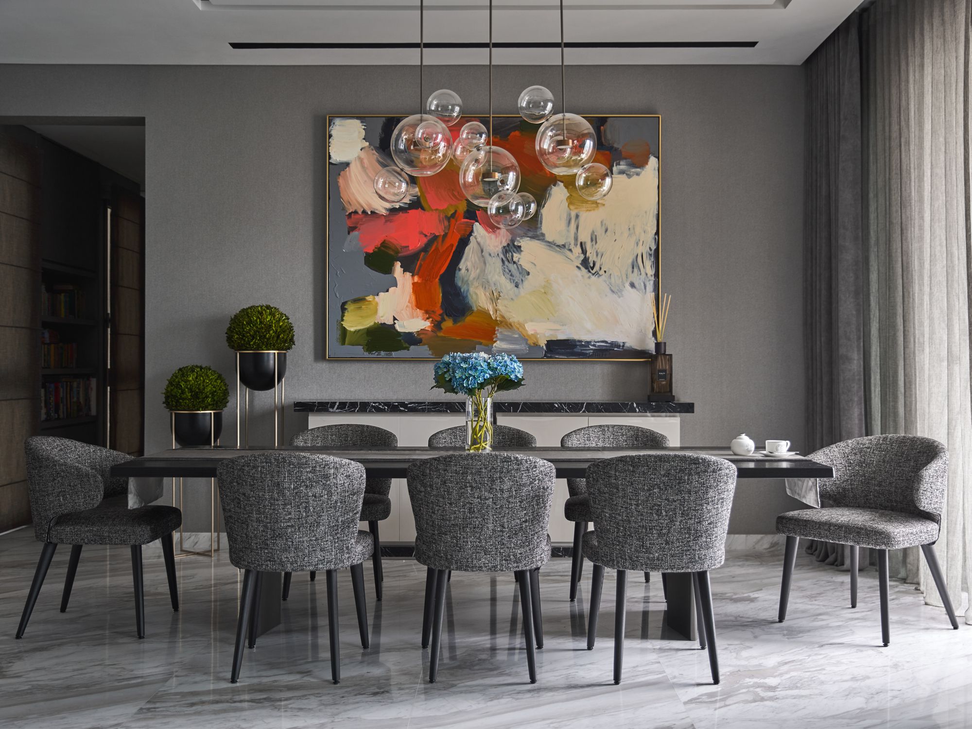 The dining area is large and spacious, featuring the complementing marble and grey combination seen throughout the apartment